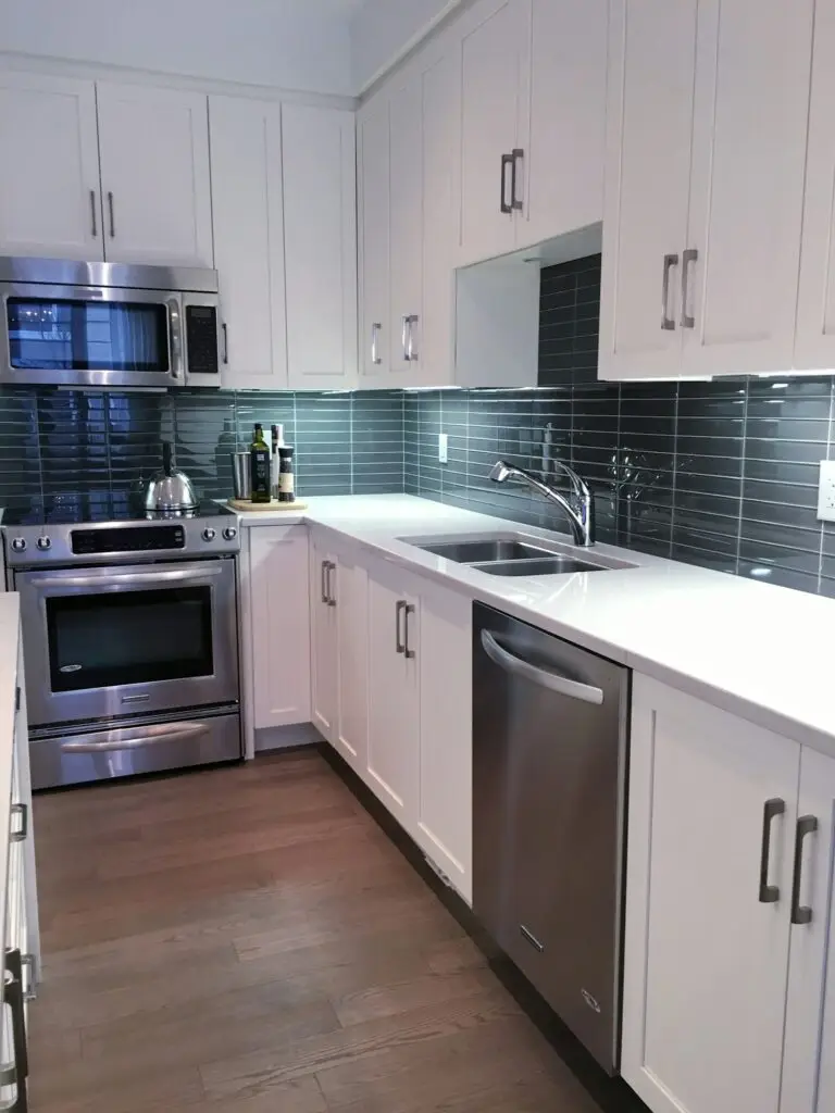 Modern kitchen with white furniture and glass tiles for backsplash tiling