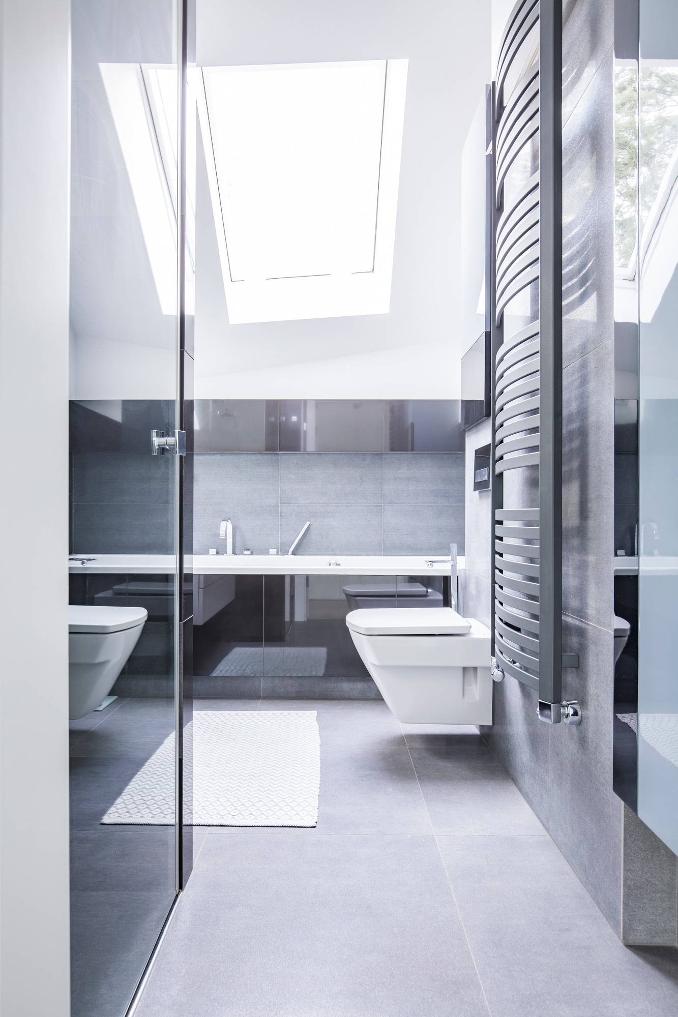 Black and white bathroom interior with reflective tiles, a ceram